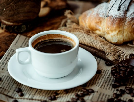 a cup of americano coffee placed on newspaper